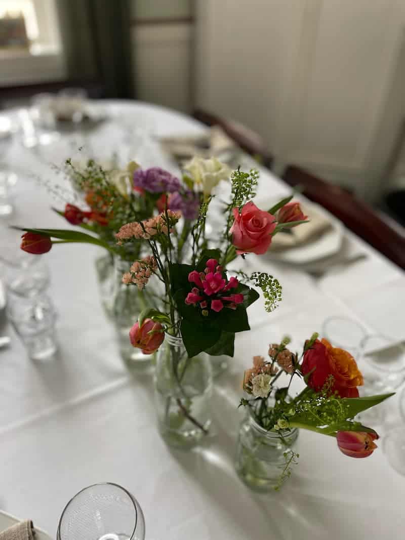Fest små blomstervaser på dækket bord